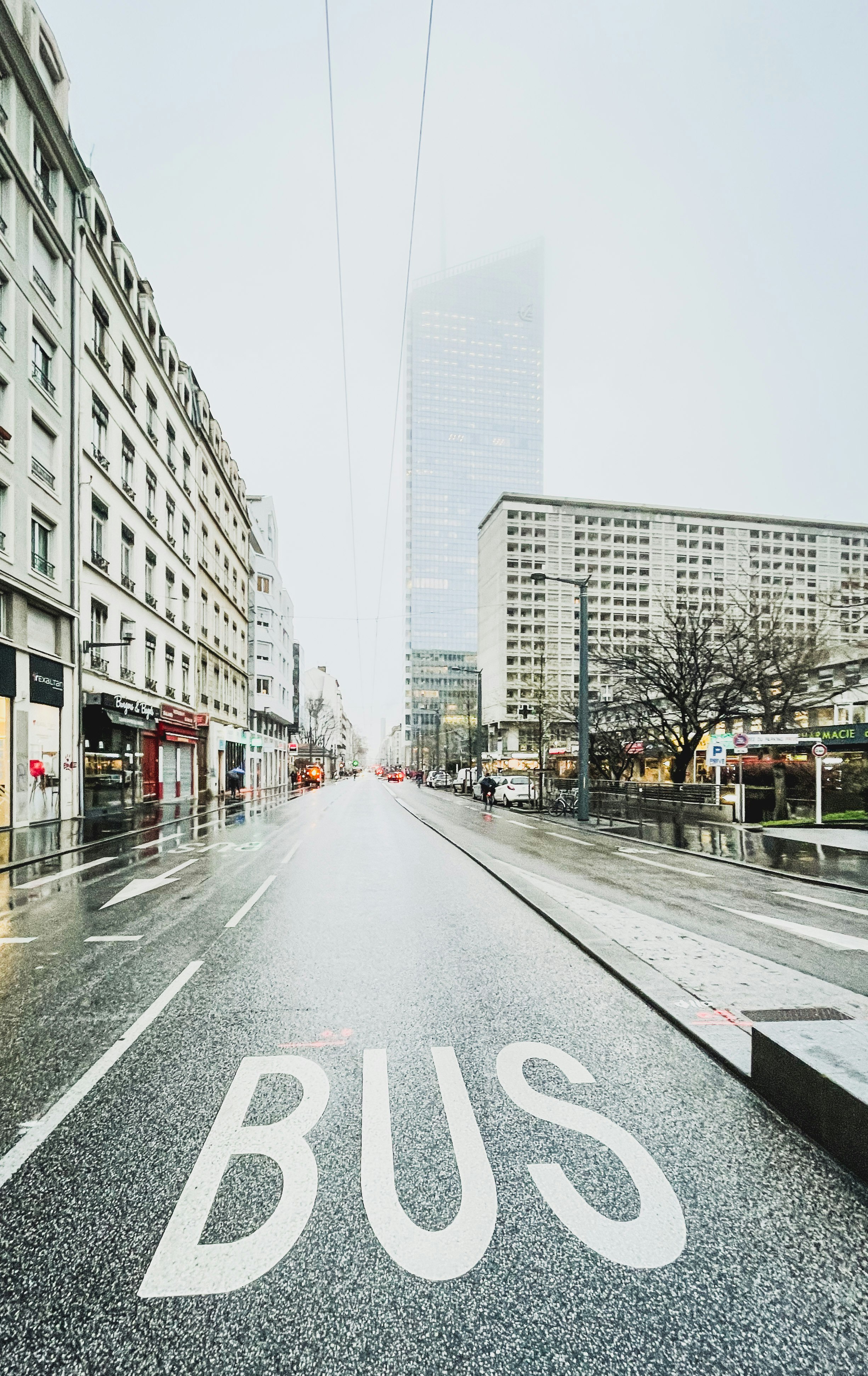 gray concrete road between high rise buildings during daytime